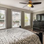 Spacious bedroom featuring elegant decor, modern furniture, and abundant natural light.