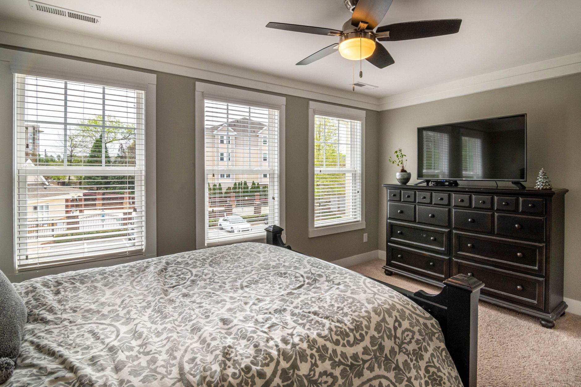 Spacious bedroom featuring elegant decor, modern furniture, and abundant natural light.